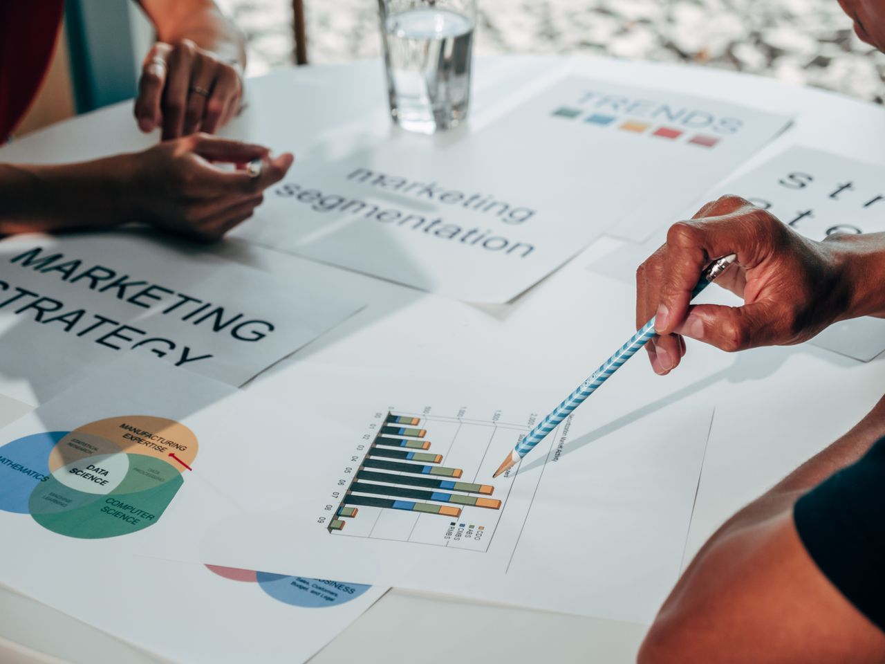 A team in an office meeting develops a marketing strategy using charts and documents.